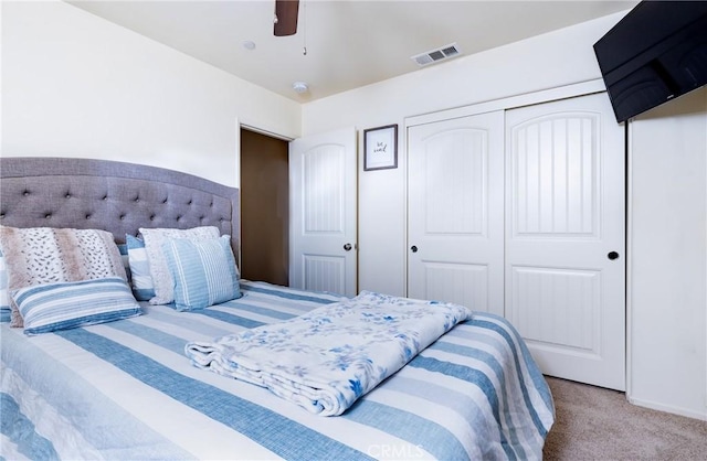 carpeted bedroom featuring ceiling fan and a closet