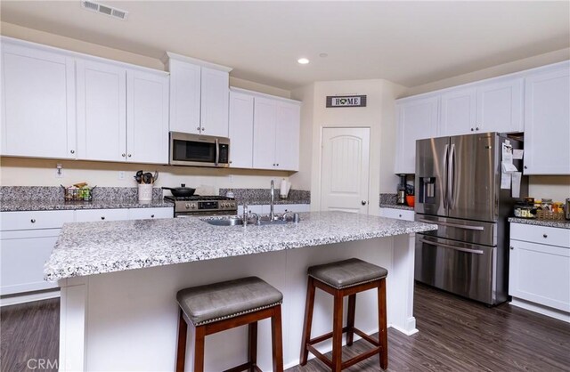 kitchen featuring white cabinetry, appliances with stainless steel finishes, sink, and a center island with sink