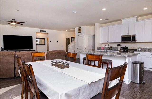 dining space with sink, dark hardwood / wood-style floors, and ceiling fan