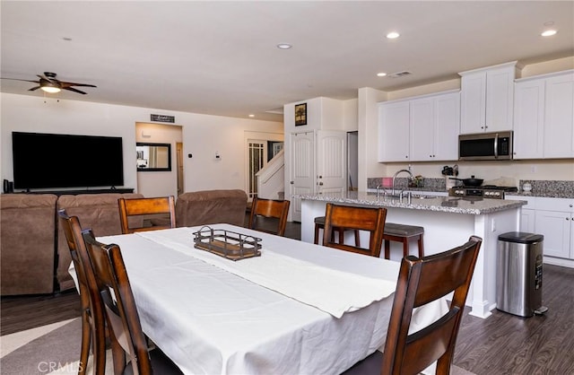 dining room with sink, dark hardwood / wood-style floors, and ceiling fan