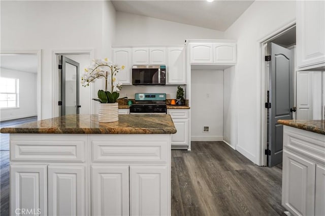 kitchen featuring appliances with stainless steel finishes, a center island, dark stone counters, and white cabinets