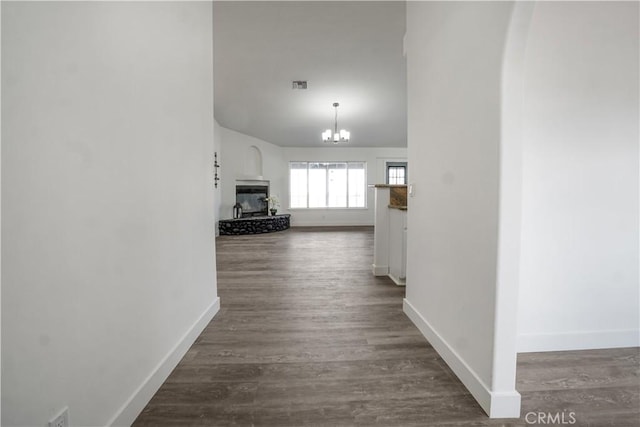 hall featuring dark hardwood / wood-style flooring and a notable chandelier