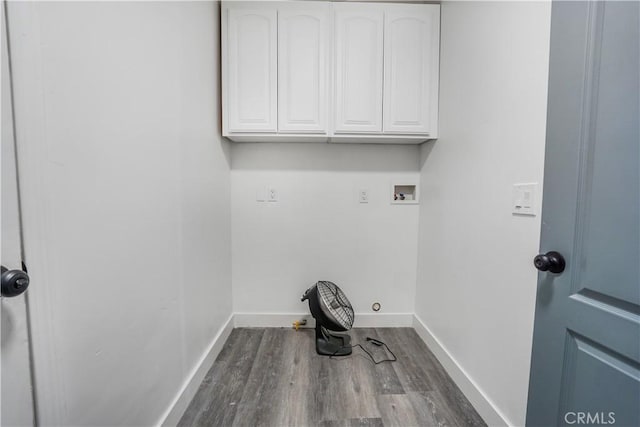 washroom featuring hookup for a washing machine, hardwood / wood-style flooring, and cabinets