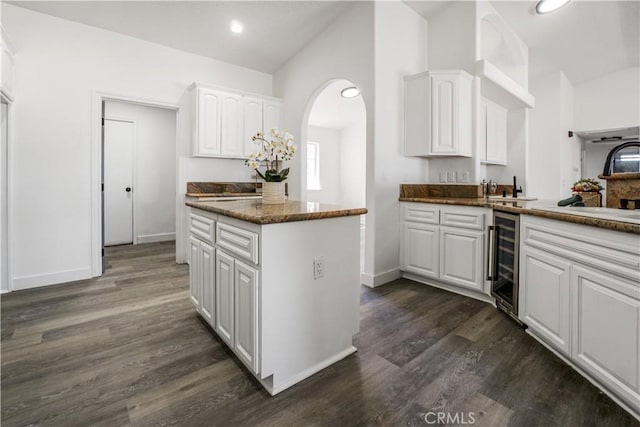 kitchen featuring sink, dark wood-type flooring, white cabinets, and dark stone counters