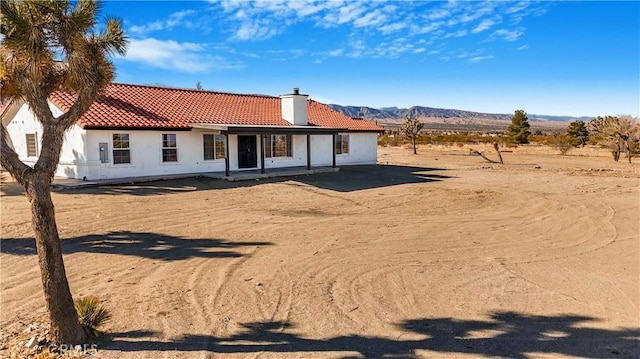 rear view of property featuring a mountain view and a patio area