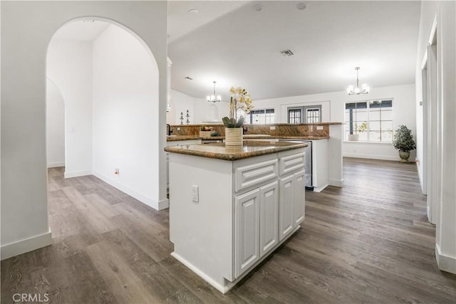 kitchen with an inviting chandelier, a center island, hanging light fixtures, and white cabinets