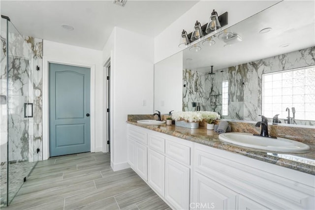 bathroom with vanity and a shower with door