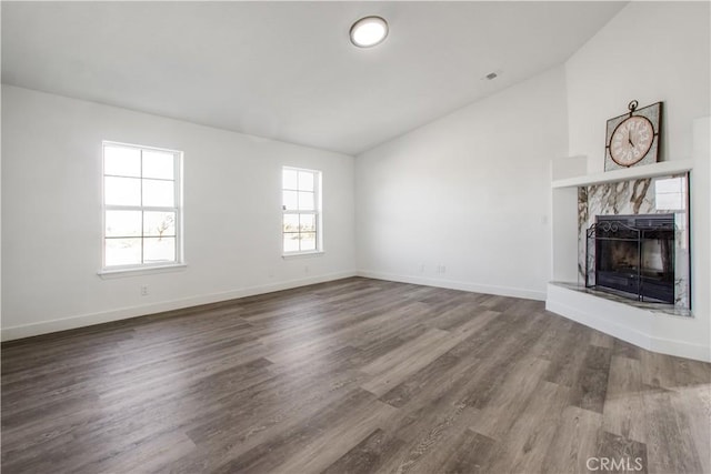 unfurnished living room featuring wood-type flooring, lofted ceiling, and a fireplace