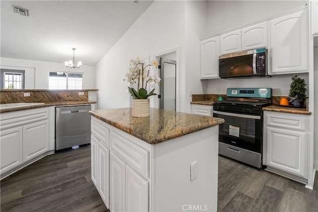 kitchen with white cabinetry, a center island, vaulted ceiling, pendant lighting, and stainless steel appliances