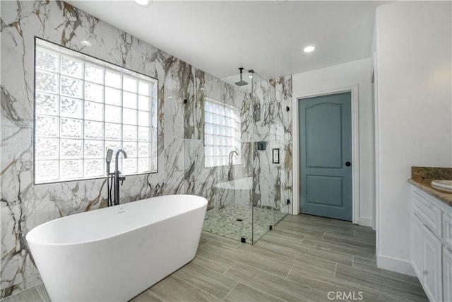 bathroom featuring vanity and shower with separate bathtub