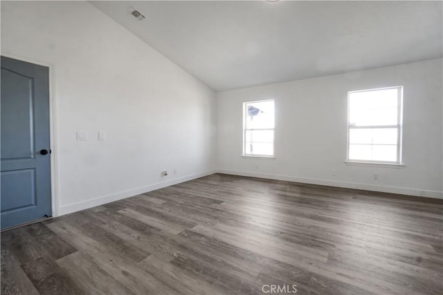 empty room with vaulted ceiling and dark hardwood / wood-style floors