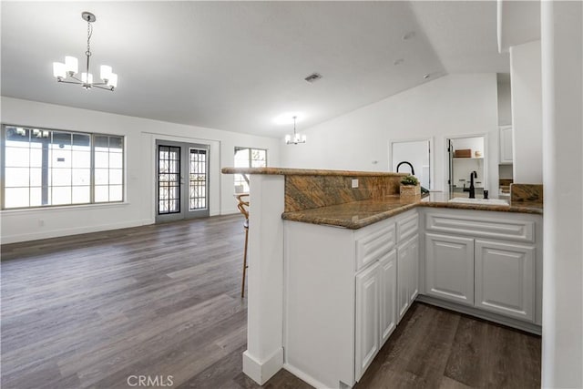 kitchen featuring a chandelier, sink, kitchen peninsula, and white cabinets