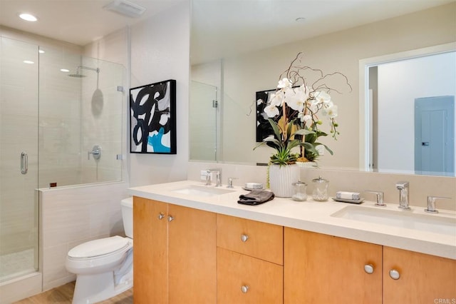 bathroom featuring vanity, toilet, and a shower with door