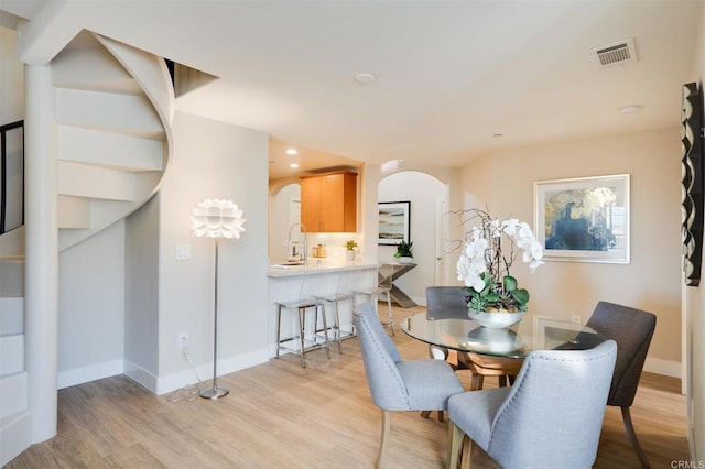 dining room featuring sink and light hardwood / wood-style flooring