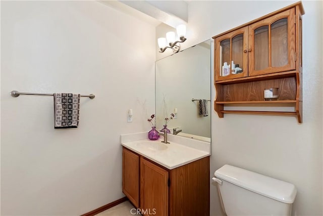 bathroom with vanity, a chandelier, and toilet