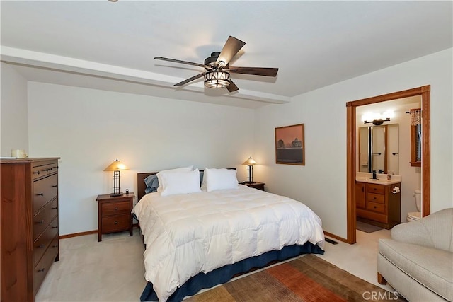 bedroom featuring ensuite bathroom, light colored carpet, and ceiling fan