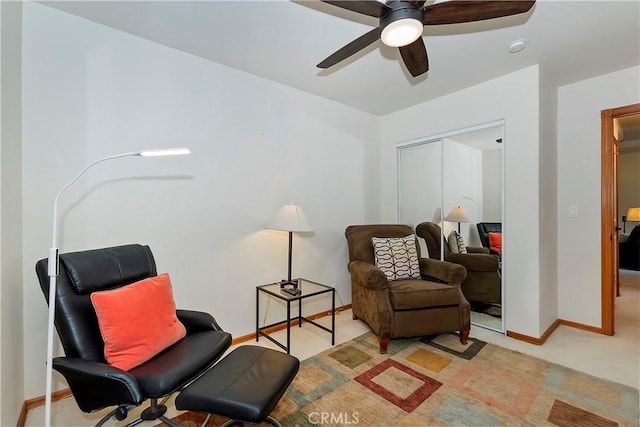 living area with light carpet and ceiling fan