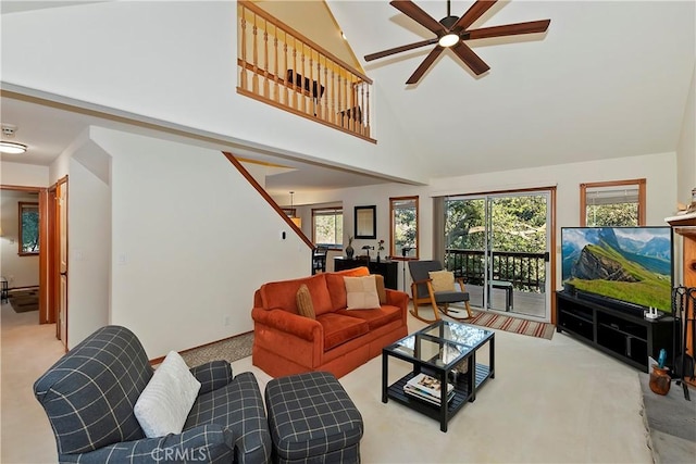 carpeted living room with a high ceiling and ceiling fan