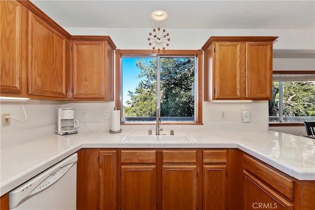 kitchen featuring sink, tile counters, and white dishwasher