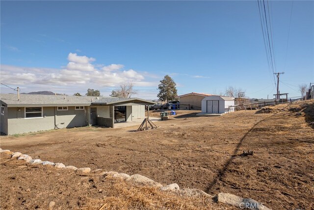 rear view of house featuring a storage shed