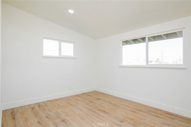 empty room featuring vaulted ceiling and wood-type flooring