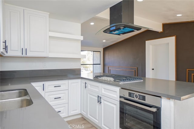 kitchen with sink, stainless steel appliances, white cabinets, island exhaust hood, and kitchen peninsula