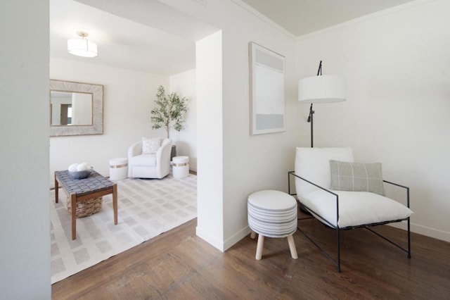 sitting room featuring wood-type flooring and ornamental molding