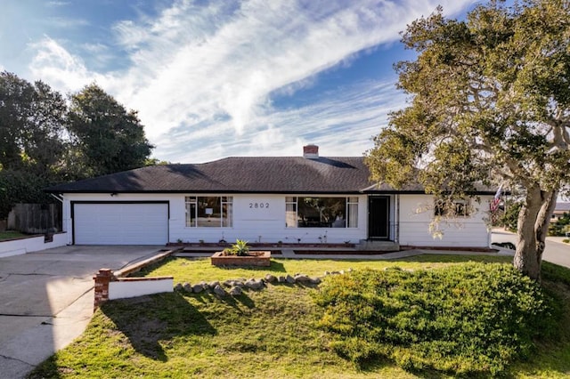 single story home featuring a garage and a front lawn