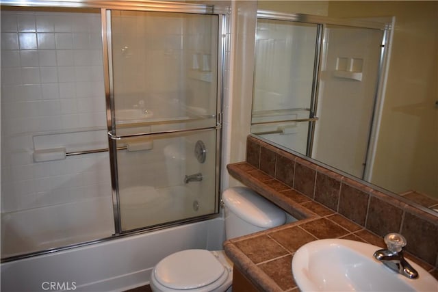 full bathroom with vanity, backsplash, shower / bath combination with glass door, and toilet