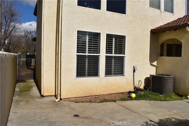 view of side of property featuring a patio and cooling unit