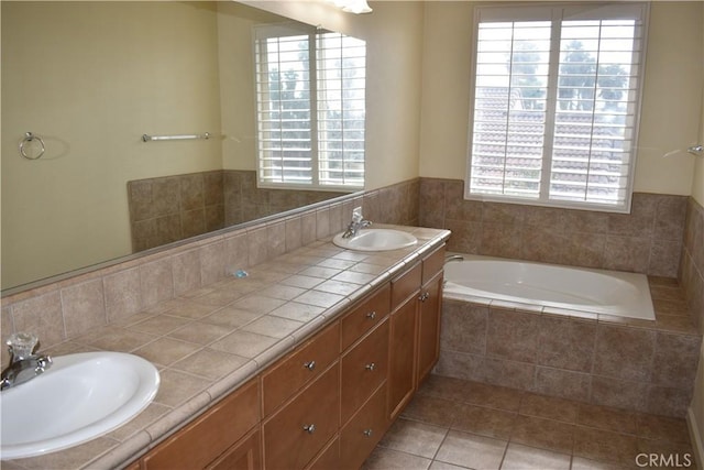 bathroom featuring tile patterned flooring, tiled tub, and vanity