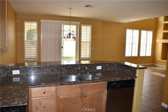 kitchen featuring sink, stainless steel dishwasher, dark stone counters, and a healthy amount of sunlight