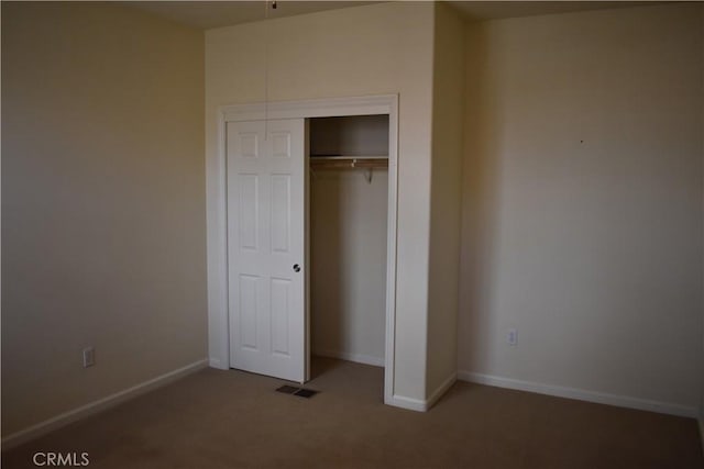 unfurnished bedroom featuring carpet floors and a closet