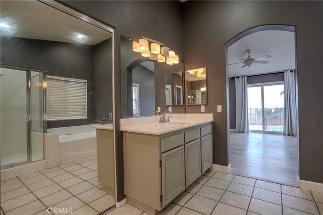 bathroom with vanity, tile patterned floors, ceiling fan, and plus walk in shower