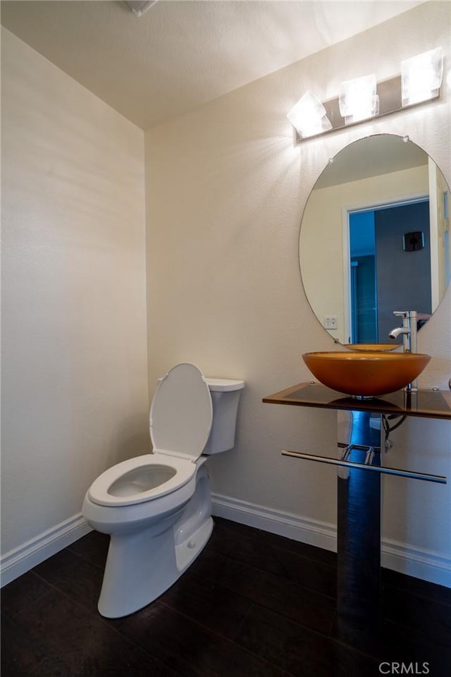 bathroom with wood-type flooring, sink, and toilet