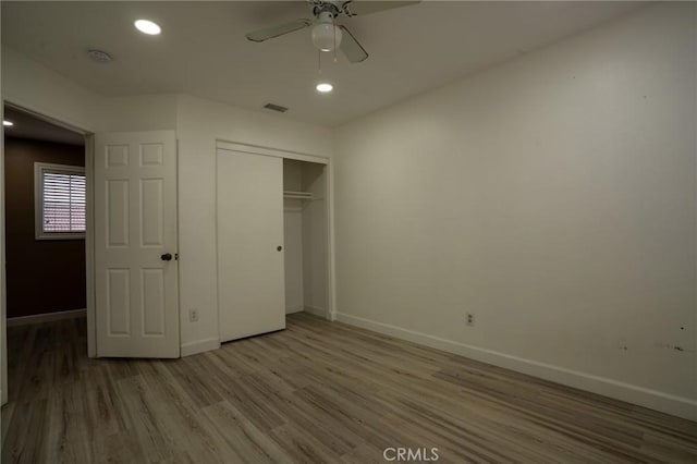 unfurnished bedroom with wood-type flooring and a closet