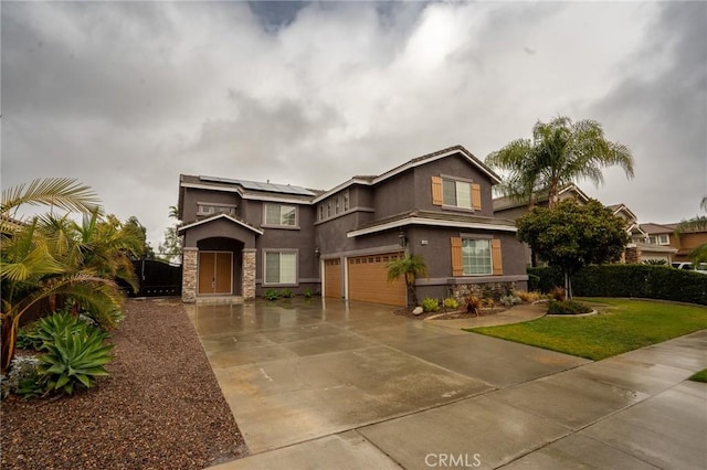 view of front of house with a garage, a front lawn, and solar panels