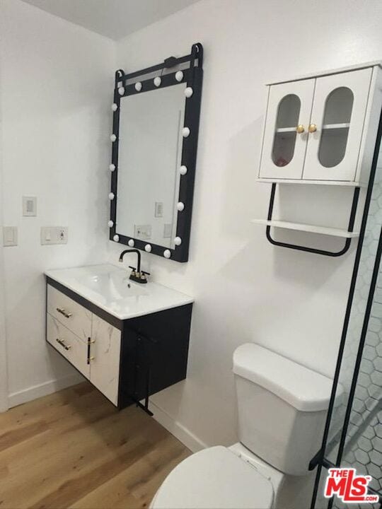 bathroom with vanity, toilet, and hardwood / wood-style floors