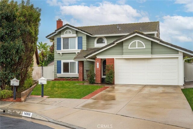 view of front of house featuring driveway, fence, a front yard, a garage, and brick siding