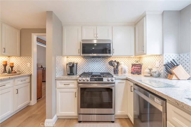 kitchen featuring light wood-type flooring, stainless steel appliances, and white cabinets