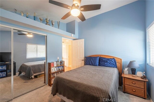 carpeted bedroom with multiple windows, a closet, and ceiling fan