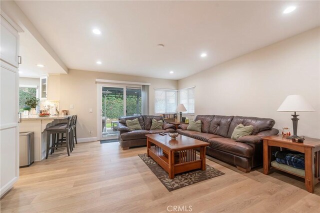 living room with light wood-style flooring, recessed lighting, baseboards, and a wealth of natural light