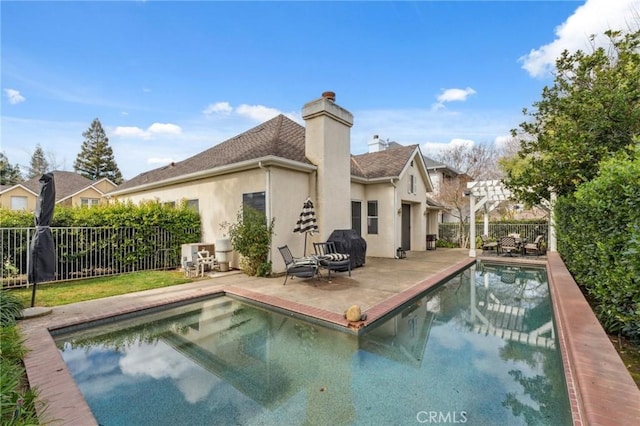 back of house with a fenced in pool and a patio