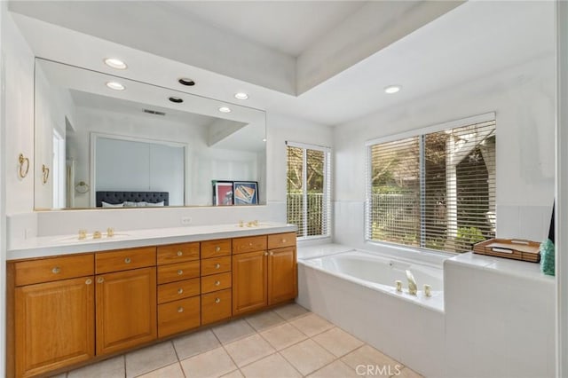 bathroom with vanity, a bathing tub, and tile patterned flooring