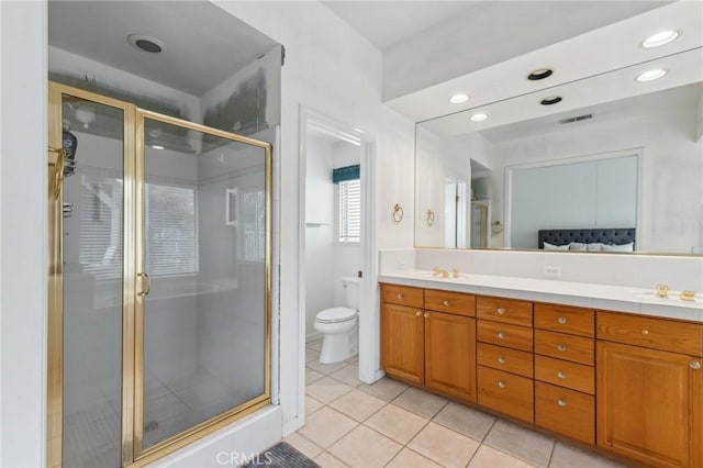 bathroom featuring tile patterned flooring, vanity, walk in shower, and toilet