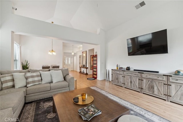 living room featuring an inviting chandelier, hardwood / wood-style floors, and plenty of natural light