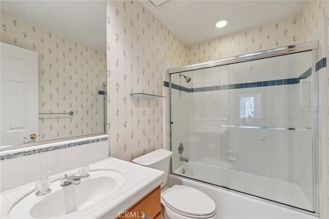 full bathroom with shower / bath combination with glass door, vanity, and toilet