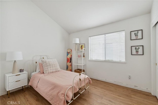 bedroom featuring lofted ceiling and light hardwood / wood-style floors