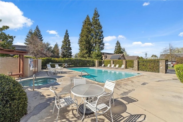 view of swimming pool featuring a hot tub and a patio