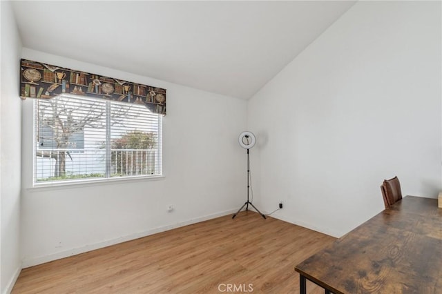 empty room with wood-type flooring and lofted ceiling